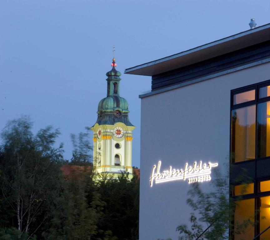 una torre de reloj en el fondo de un edificio en Fürstenfelder Hotel, en Fürstenfeldbruck