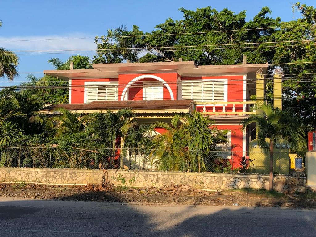 una casa roja al lado de una calle en Negril Beachside, en Negril