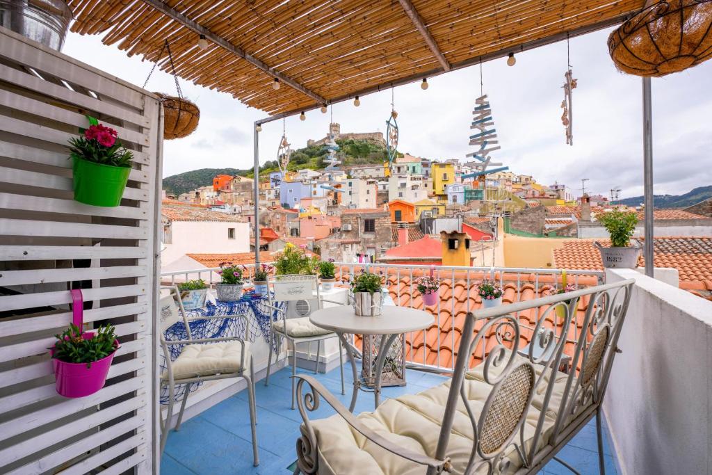 d'un balcon avec des tables et des chaises offrant une vue sur la ville. dans l'établissement Domo 'e sa rosa, à Bosa