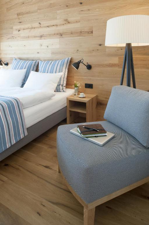 Hotel M120, a bedroom with a bed and a chair with a lamp at Hotel M120 in Munich