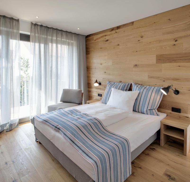 - une chambre avec un grand lit et un mur en bois dans l'établissement Hotel M120, à Munich