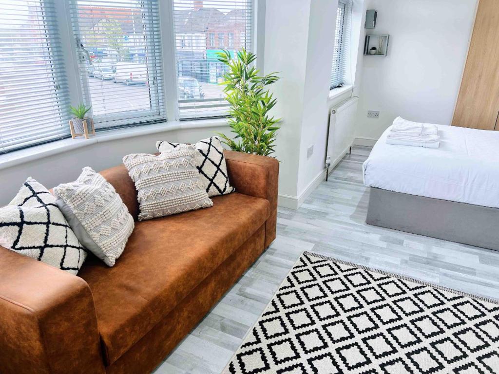 uma sala de estar com um sofá e uma cama em Studio Rooms Ensuite Newbury Park London em Seven Kings