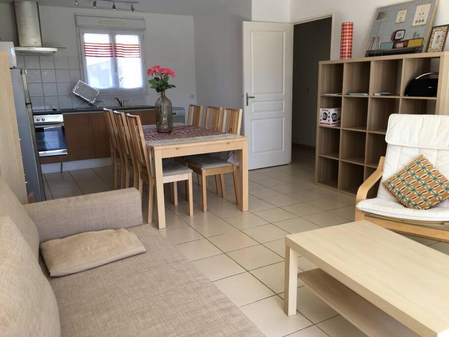 eine Küche und ein Wohnzimmer mit einem Tisch und Stühlen in der Unterkunft Lucie in Hyères