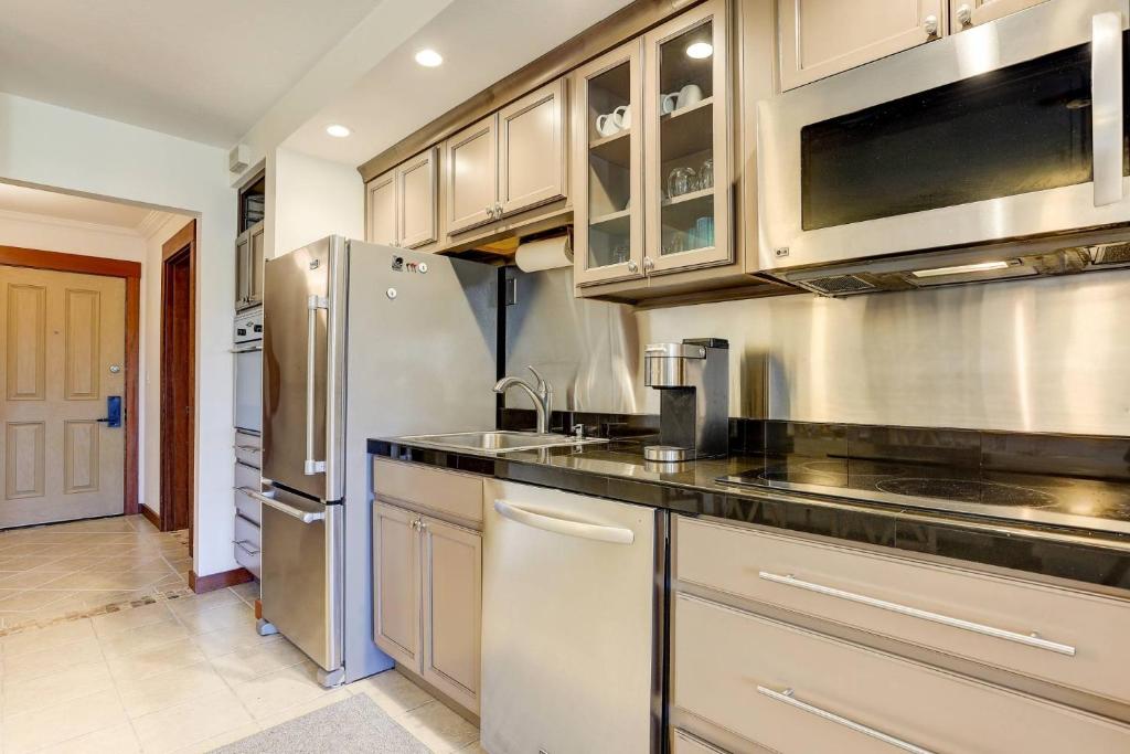 a kitchen with stainless steel appliances and wooden cabinets at 7th Mountain Bliss in Bend