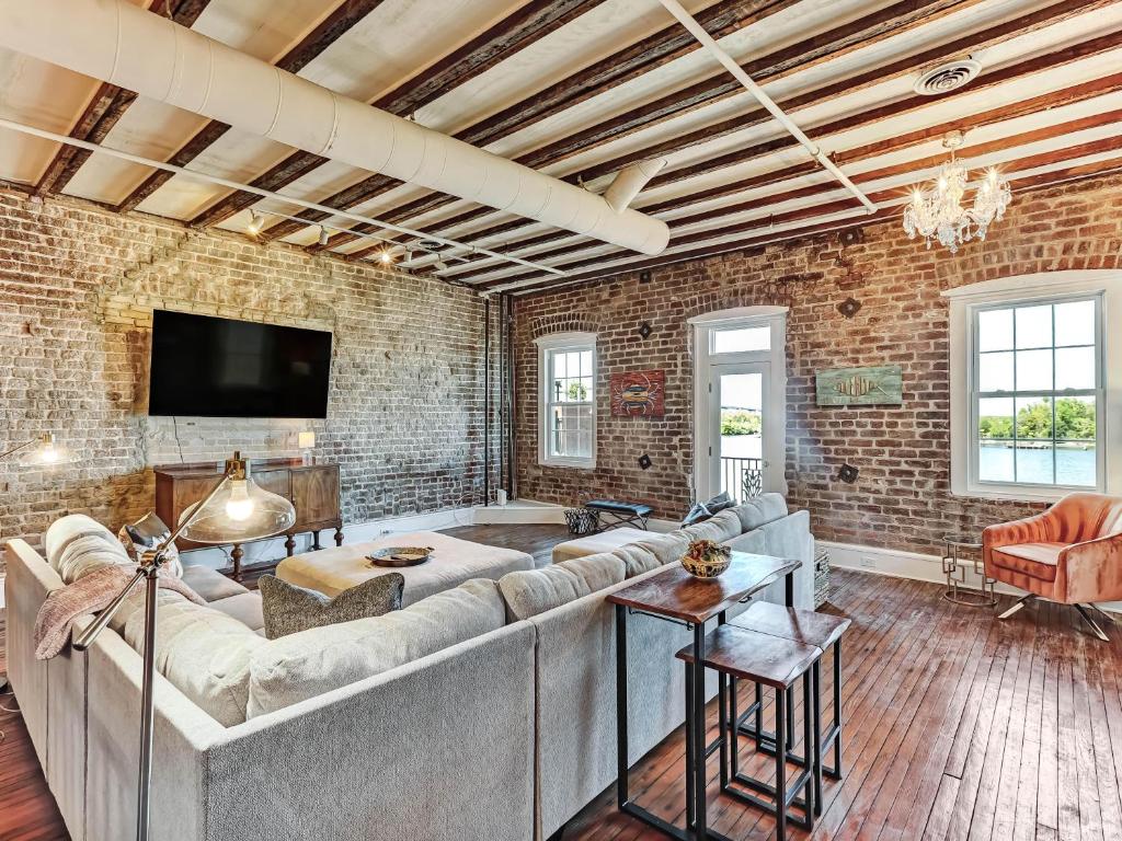 a living room with a couch and a brick wall at Riverview Terrace in Savannah