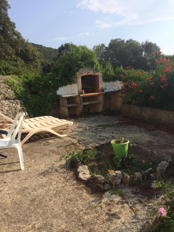 een patio met een stoel en een open haard bij Casa Minana in Propriano