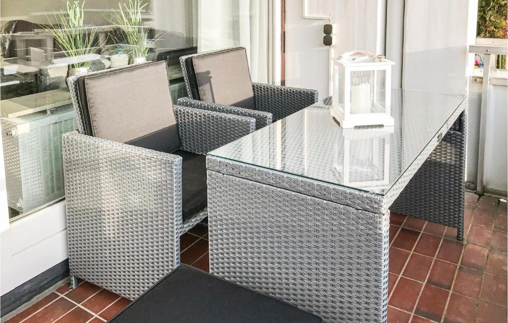 a glass table with two chairs and a glass table and chairsearcher at Gorgeous Apartment In Büsum With Wifi in Büsum
