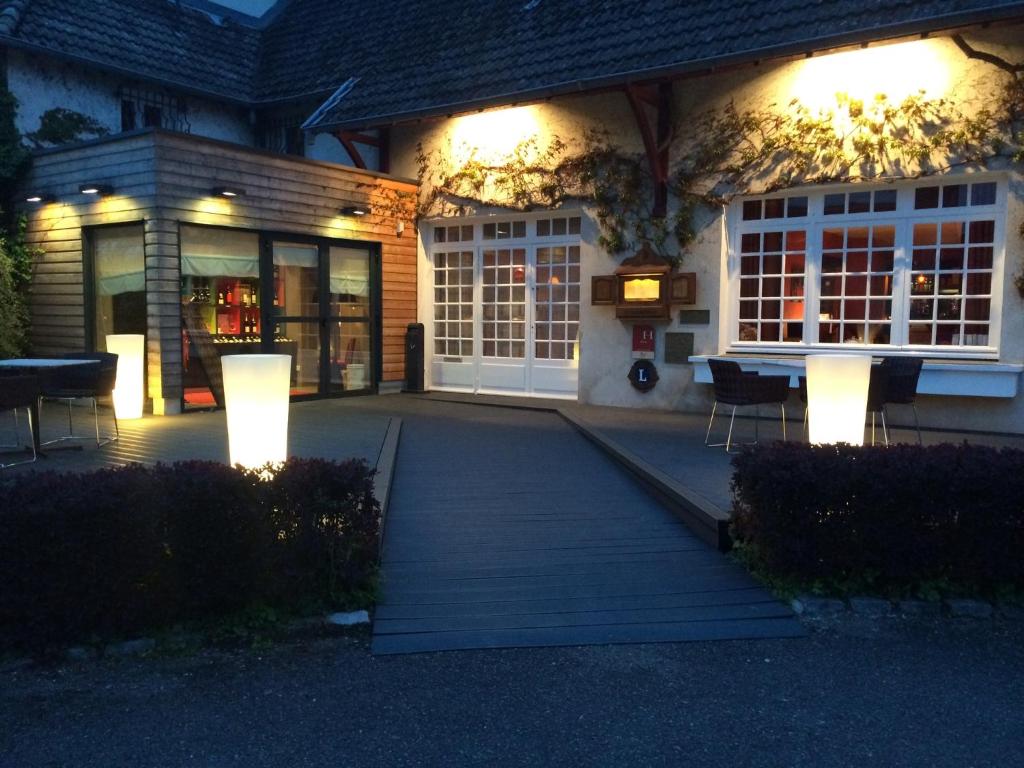 a house with a porch at night with lights at Hotel La Chaumiere in Dole