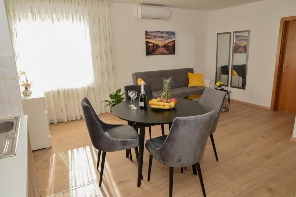 sala de estar con mesa negra y sillas en Apartment Longin, en Zadar