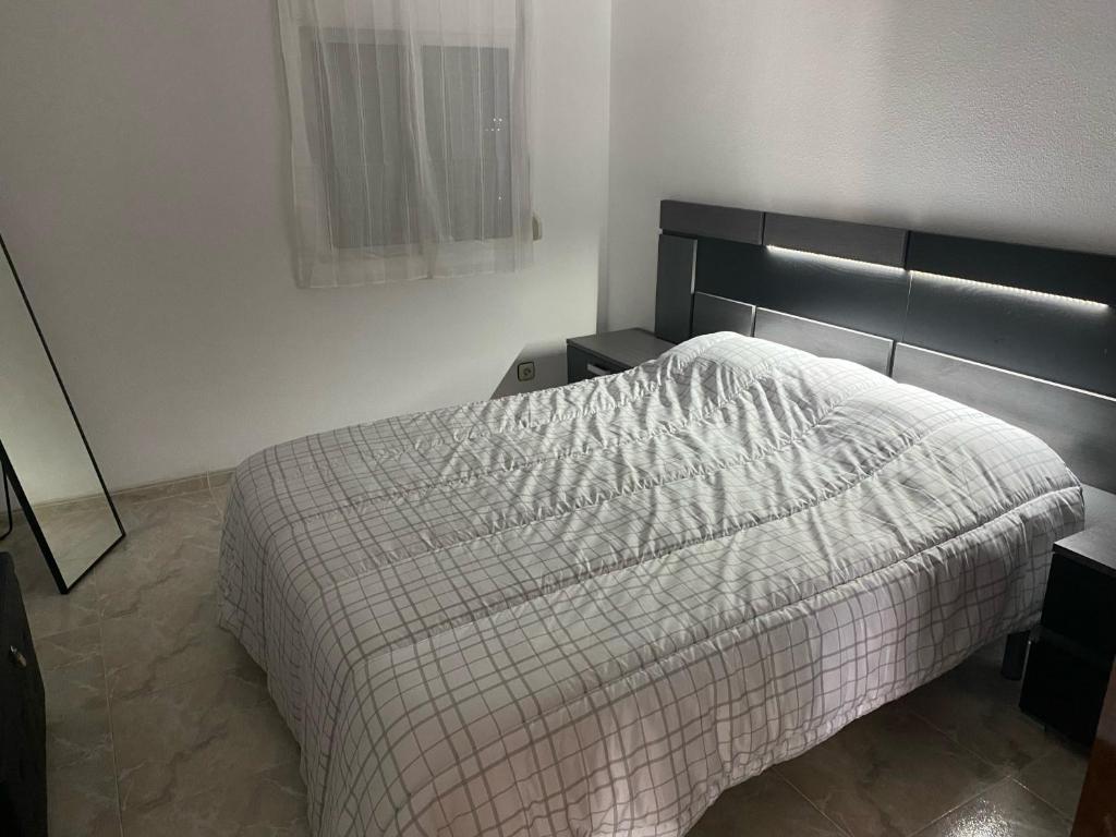 a bedroom with a bed with a blanket on it at Salou Llevant parking gratuit in Salou