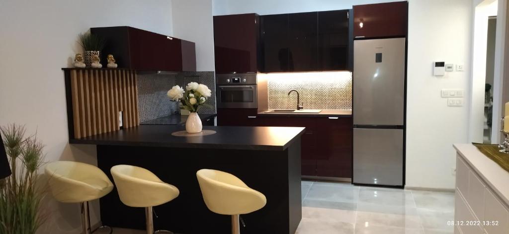 a kitchen with a island with a vase of flowers at City Center Apartment III in Nitra