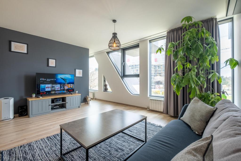 a living room with a couch and a table at Arcadia Apartment, Park and Parking in Sofia