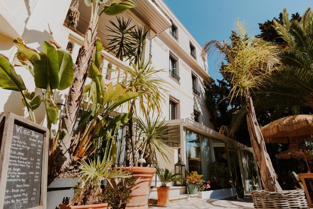un bâtiment avec un tas de plantes devant lui dans l'établissement Hôtel Le Petit Castel, à Antibes