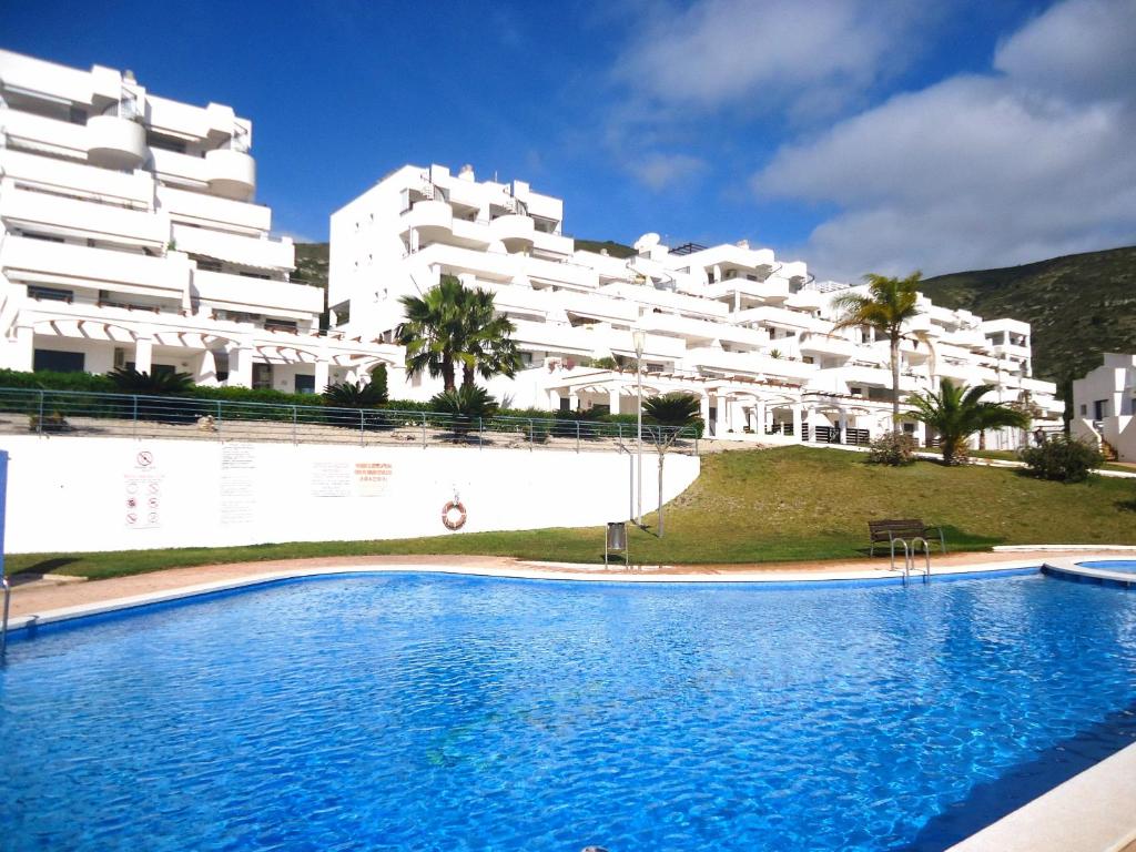 a swimming pool in front of a large white building at Tierra de Irta P B LEK in Peñíscola