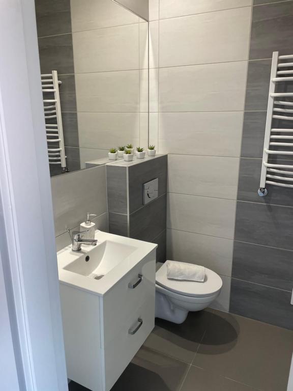 a bathroom with a white sink and a toilet at Apartament z sypialnią Giżycko in Giżycko