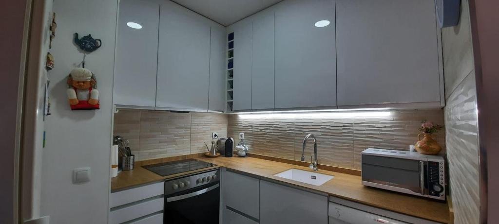 A kitchen or kitchenette at Apartamento con terraza privada, piscina y pkg