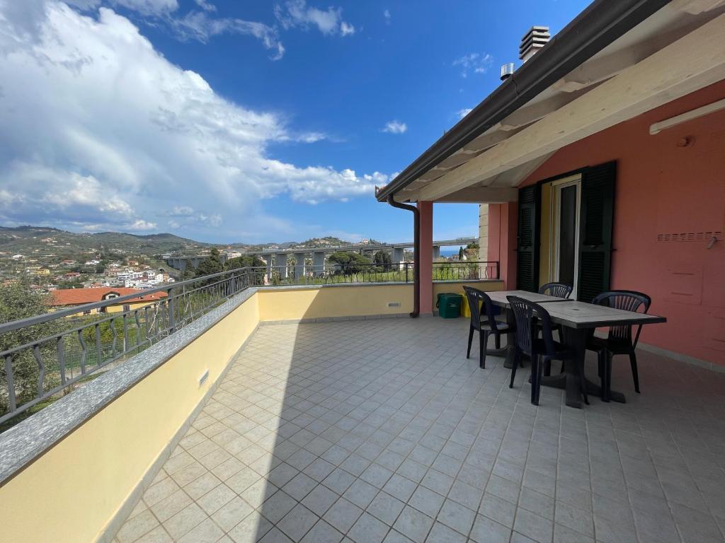 a patio with tables and chairs on a balcony at La Quercia casa vacanza Imperia in Imperia