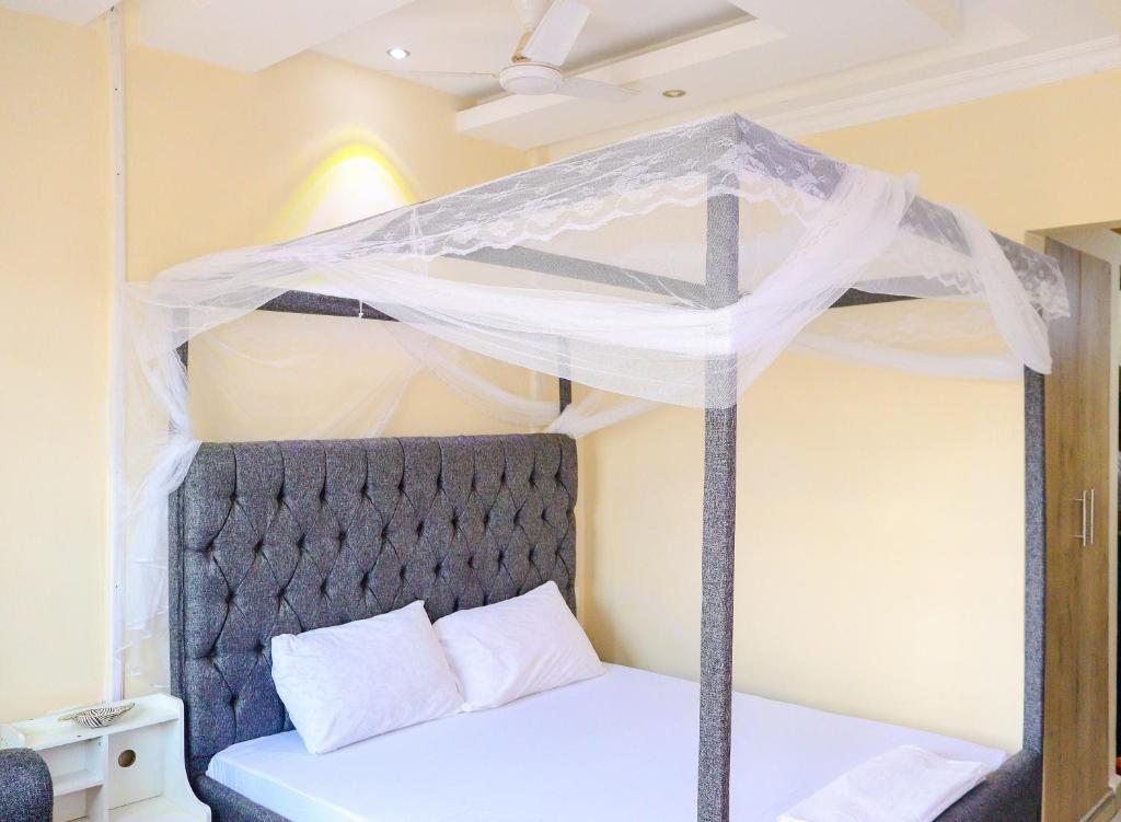 ein Schlafzimmer mit einem Himmelbett in der Unterkunft Khalisee Homes Studio Apartment 2 in Voi