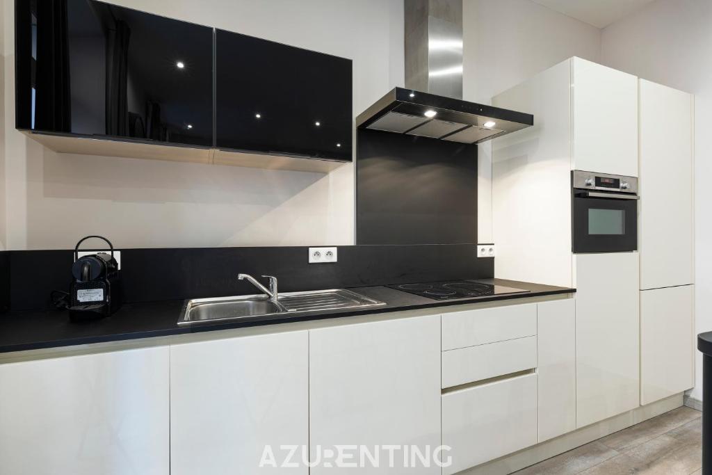 kuchnia z białymi szafkami i zlewem w obiekcie Beautiful Stay - Azurenting w Cannes