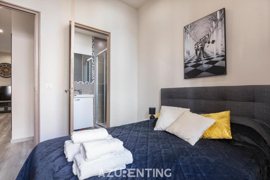 sypialnia z niebieskim łóżkiem i ręcznikami na nim w obiekcie Beautiful Stay - Azurenting w Cannes