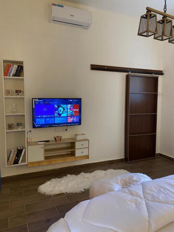 sala de estar con TV de pantalla plana en la pared en MiaDabia Supreme, en Madaba