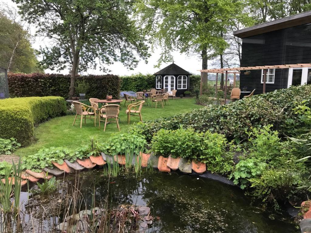 a garden with a pond in front of a house at Bêd en Brochje de Hollen in Ryptsjerk