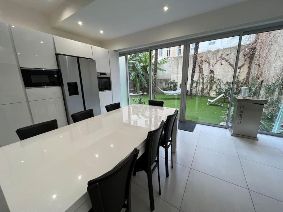 une cuisine avec une grande table blanche et des chaises dans l'établissement Amazing Stay - Azurenting, à Cannes