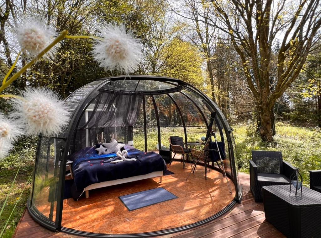 a bed in a gazebo on a deck at Dôme Atmo'sphère, la tête dans les étoiles avec accès piscine in Saint-Évarzec