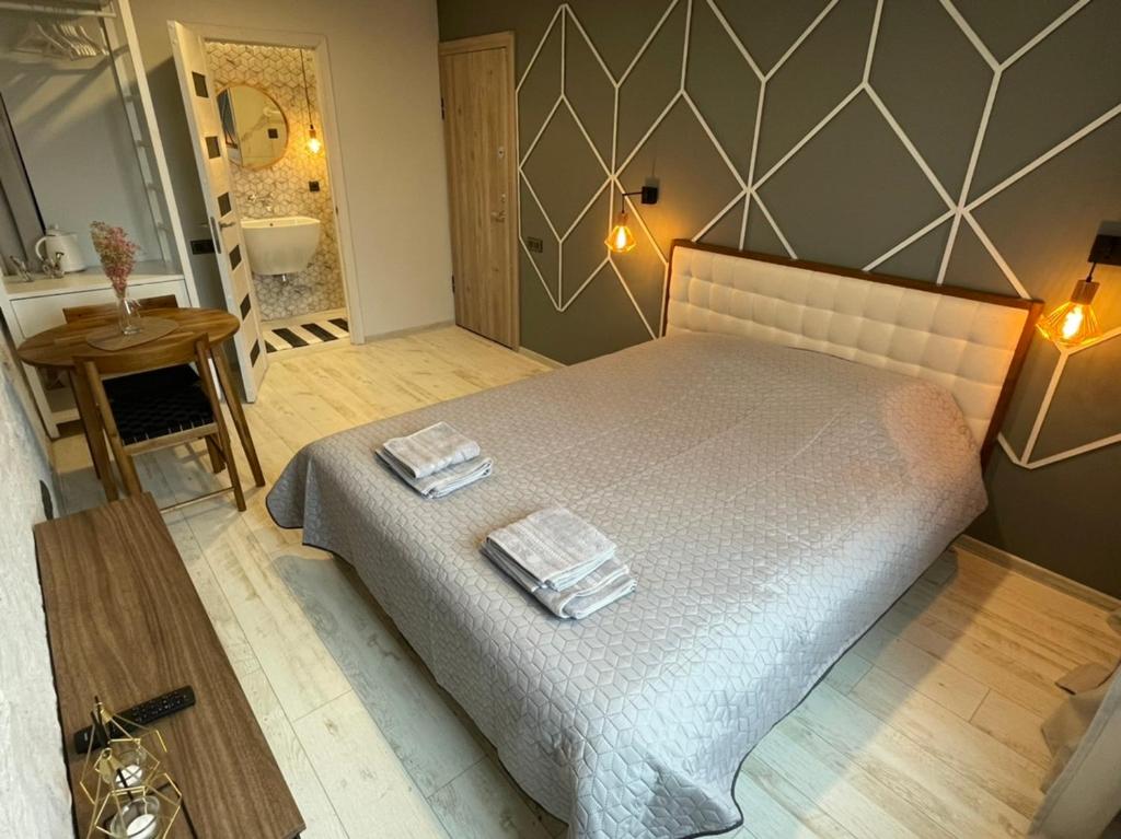 a bedroom with a bed with two towels on it at Central place with lake view in Šiauliai