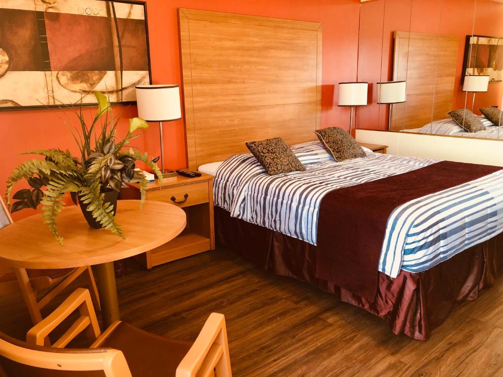 コーンウォールにあるMartin's Innのベッドとテーブルが備わるホテルルームです。