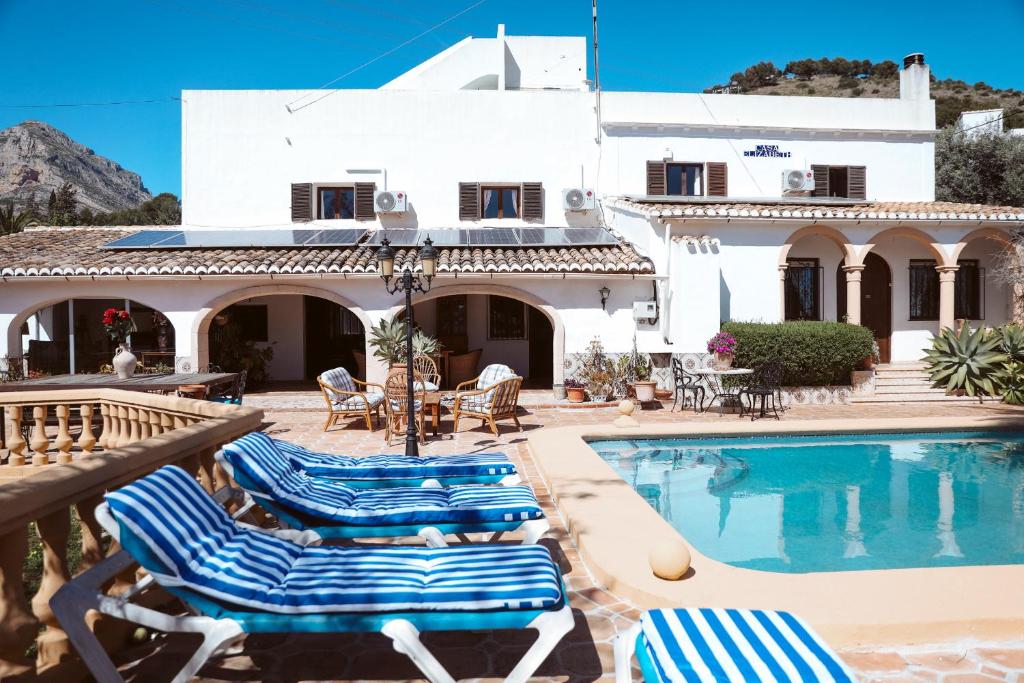 een villa met een zwembad en een huis bij Casa Elizabeth in Jávea