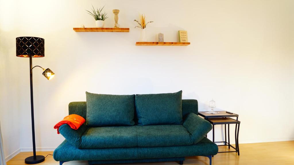a green couch in a living room with a lamp at Ferienwohnung Schwarzalb 