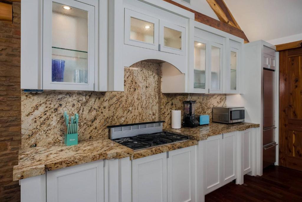 a kitchen with white cabinets and a counter top at Beacon Log Cabin in Austin