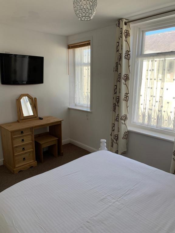 1 dormitorio con 1 cama, TV y ventana en Delamere holiday flat, en Blackpool