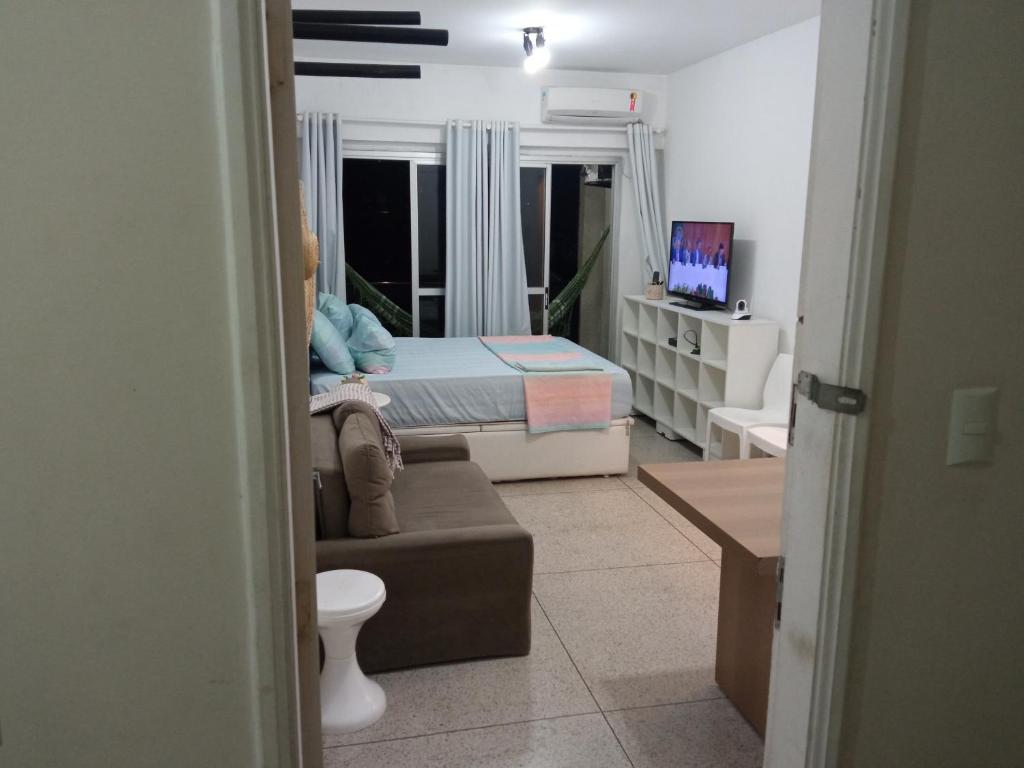 ein Schlafzimmer mit einem Bett und einem Sofa in einem Zimmer in der Unterkunft Apto frente ao mar, ar cond. frio e Wi-Fi in São Vicente