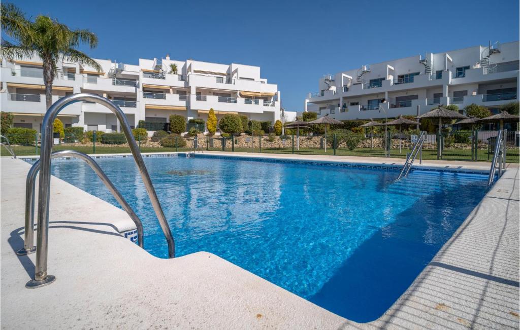 uma piscina em frente a um grande edifício em Gorgeous Apartment In Conil De La Frontera With Kitchen em Conil de la Frontera