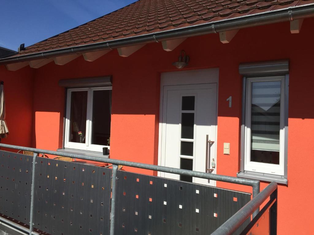 a red house with two windows and a fence at Gästehaus Durst in Rust