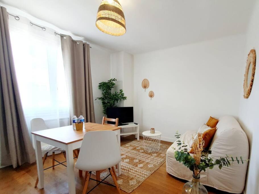 uma sala de estar com um sofá branco e uma mesa em Le Cosy Palm Tree by Madame Conciergerie em Bruz