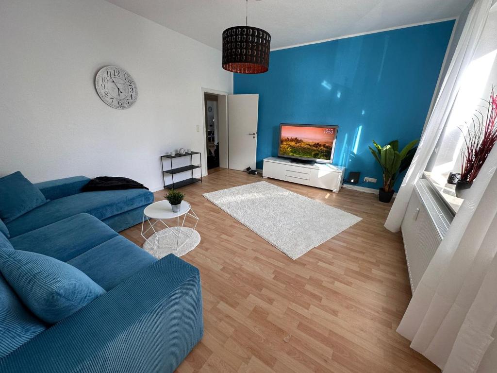 a living room with a blue couch and a tv at Dream Living 1 im Essener Süden in Essen
