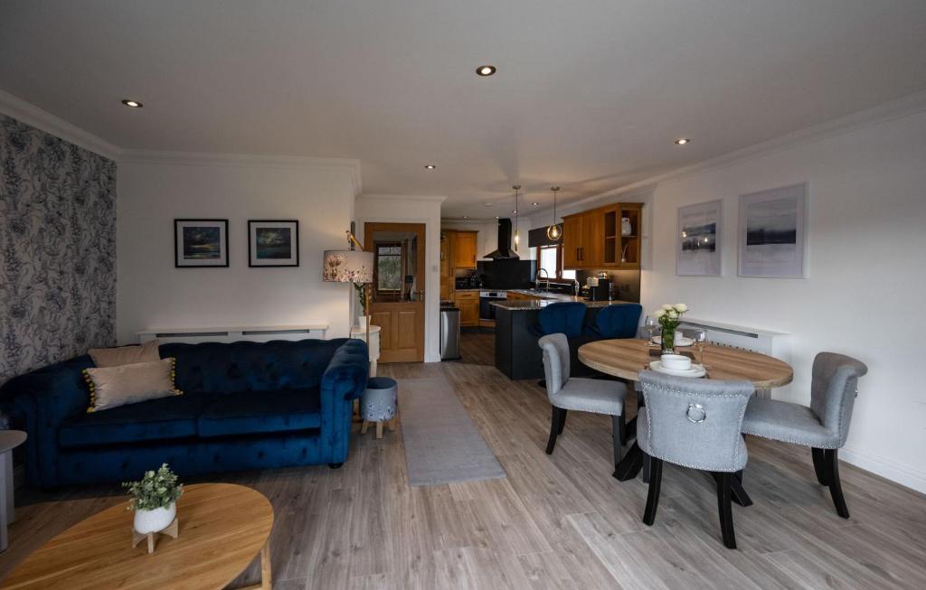 a living room with a blue couch and a table at Canalside Apartment in Fort William