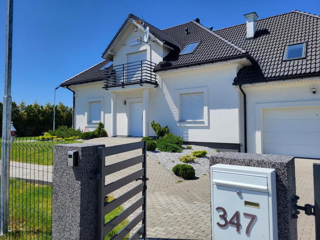 a house with a gate and a house with a garage at Villa Bella Sauna & Jacuzzi in Międzywodzie