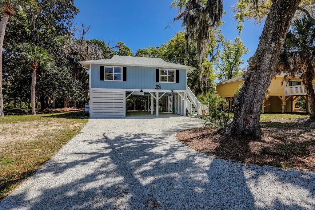 a house with a tree in front of a driveway at C Turtle in Edisto Island