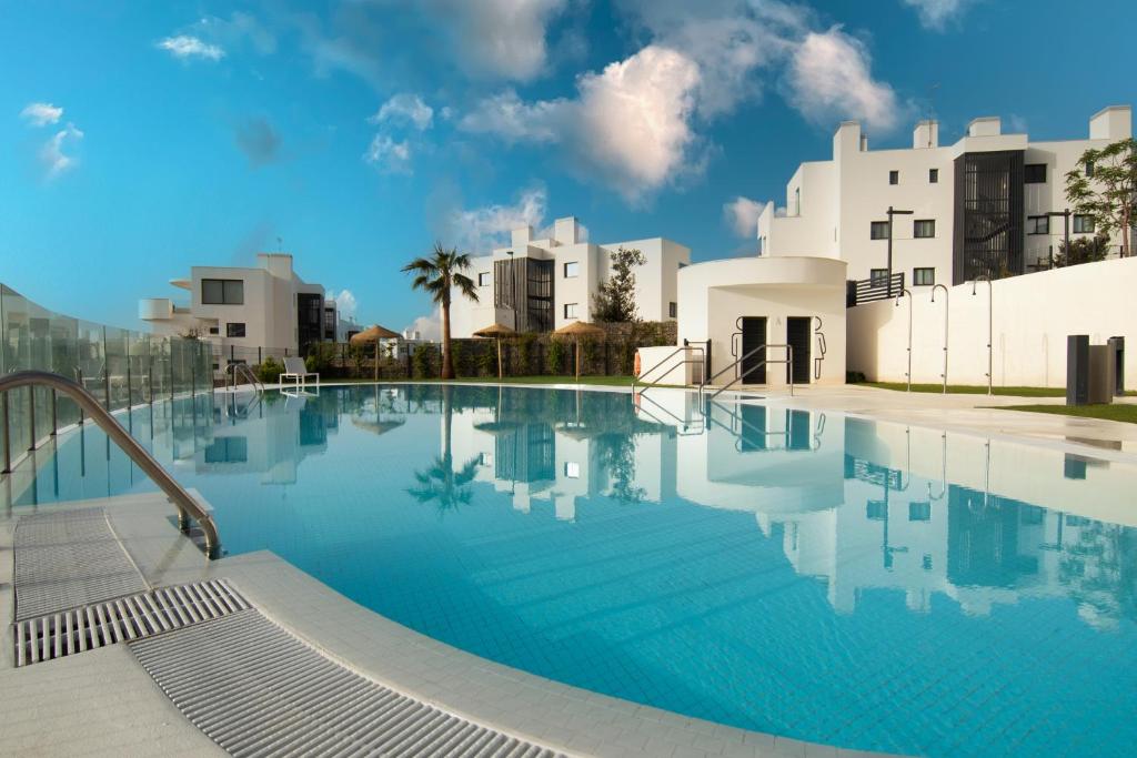 una piscina con edifici sullo sfondo di Mara's Apartments Higueron West - Like A House - 246 Square Meters of Private Terrace & Garden - Morning and Evening Sun a Fuengirola