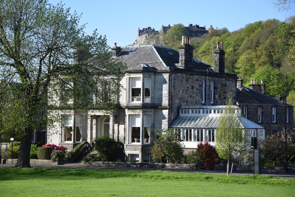 a large house with a hill in the background at Victoria Square & The Orangery in Stirling