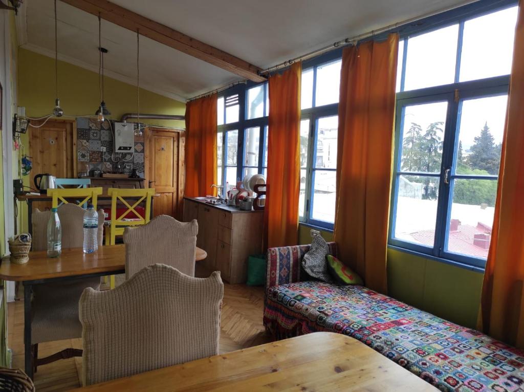 un soggiorno con tavolo e alcune finestre di Hostel ERA a Tbilisi City