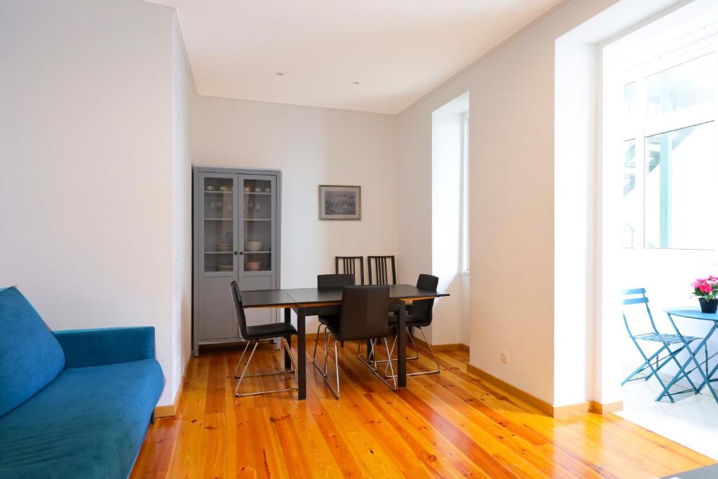 a living room with a blue couch and a table at Lisboa Sweet Family Homestay in Lisbon