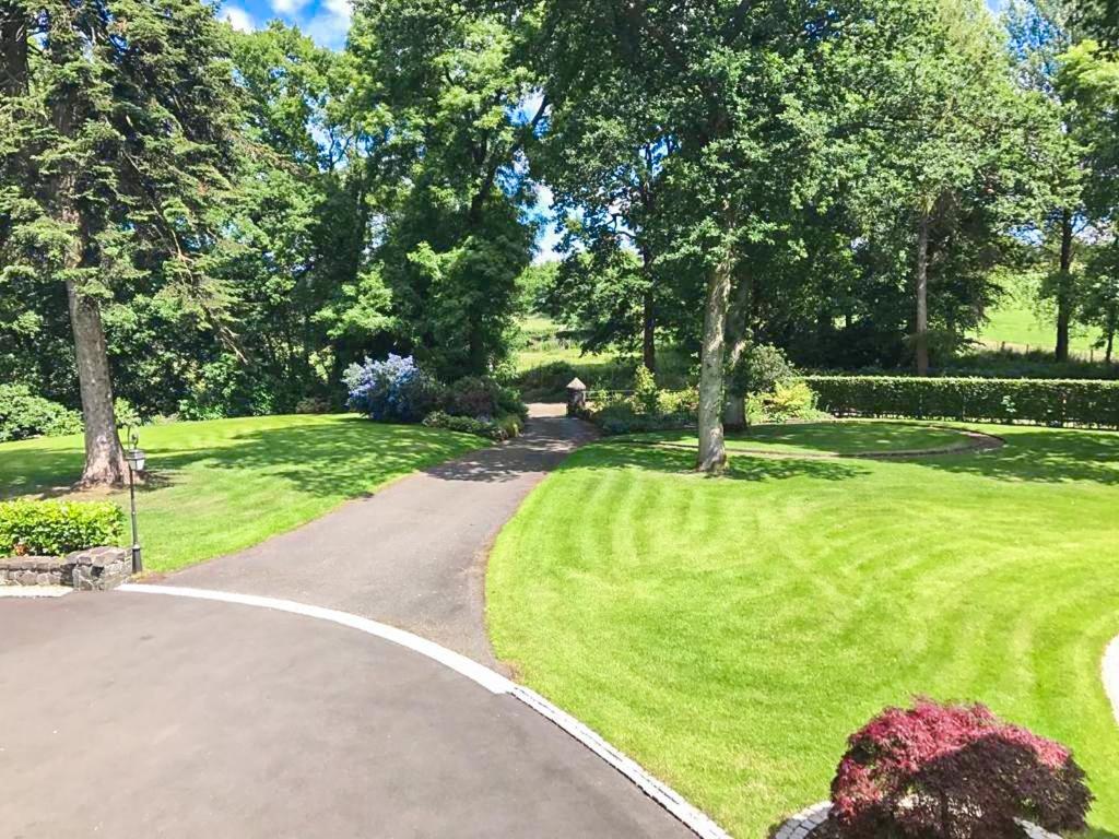 a walkway through a park with trees and grass at Blackberry Loft - a Hidden Gem in Templepatrick