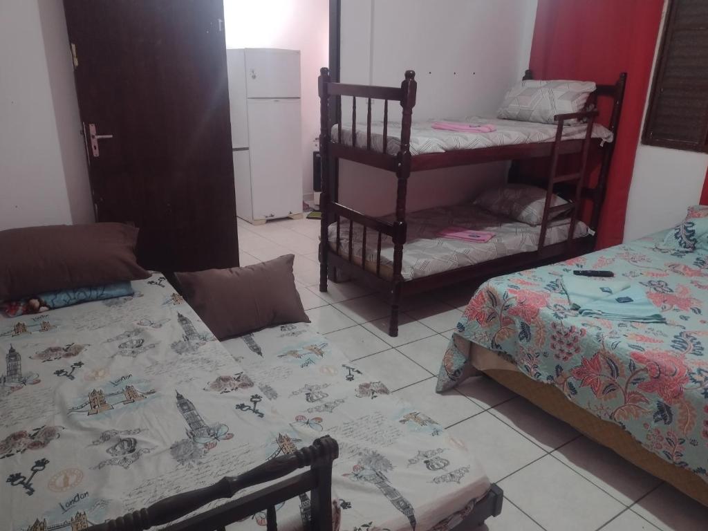 a room with two bunk beds and a kitchen at Apartamento Encantador in Guaratinguetá