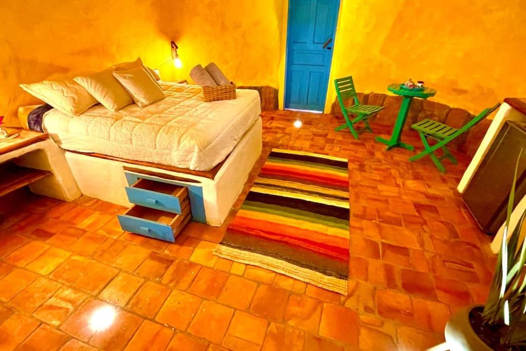 1 dormitorio con cama y alfombra colorida en Hermoso Glamping Santorini, en Barichara