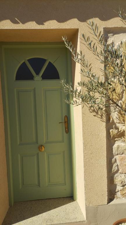 a green door on the side of a building at Casa rural El olivo in Puigmoreno